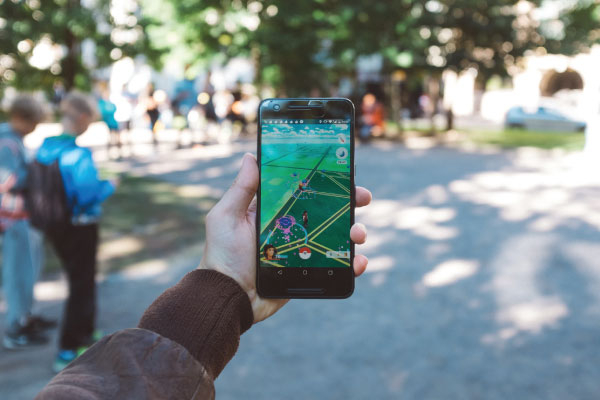 Holding phone with pokemon go open in park