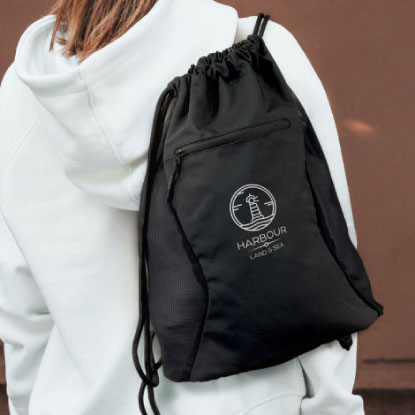 Woman in white hoodie wearing promotional backsack