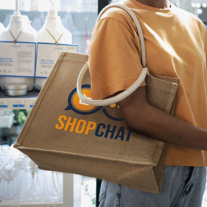 Woman with a jute shopping bag that has a logo printed on it