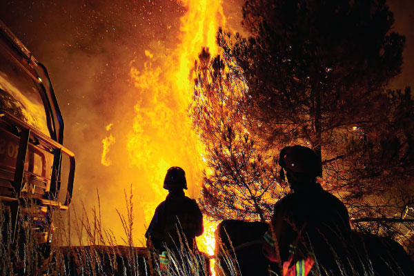 Bush Fire with firefighters in foreground.