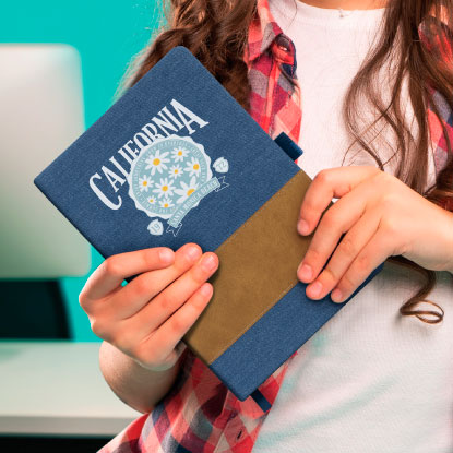 Woman holding a blue promotional notebook with a printed logo on it