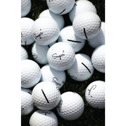 Branded golf balls scattered on grass.