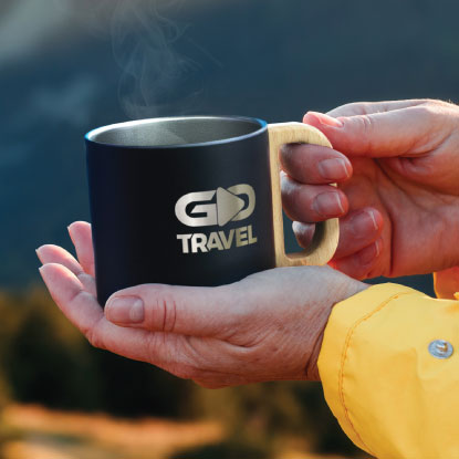 Person holding promotional metal mug with GO Travel branding on it