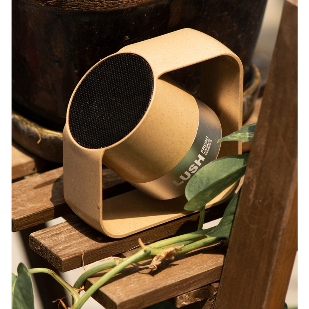 Custom Branded Eco Bluetooth Speaker – Sustainable Promotional Merchandise for Corporate Gifting and Events Branded eco Bluetooth speaker made from recycled wheat straw material with custom logo, styled in a natural outdoor setting