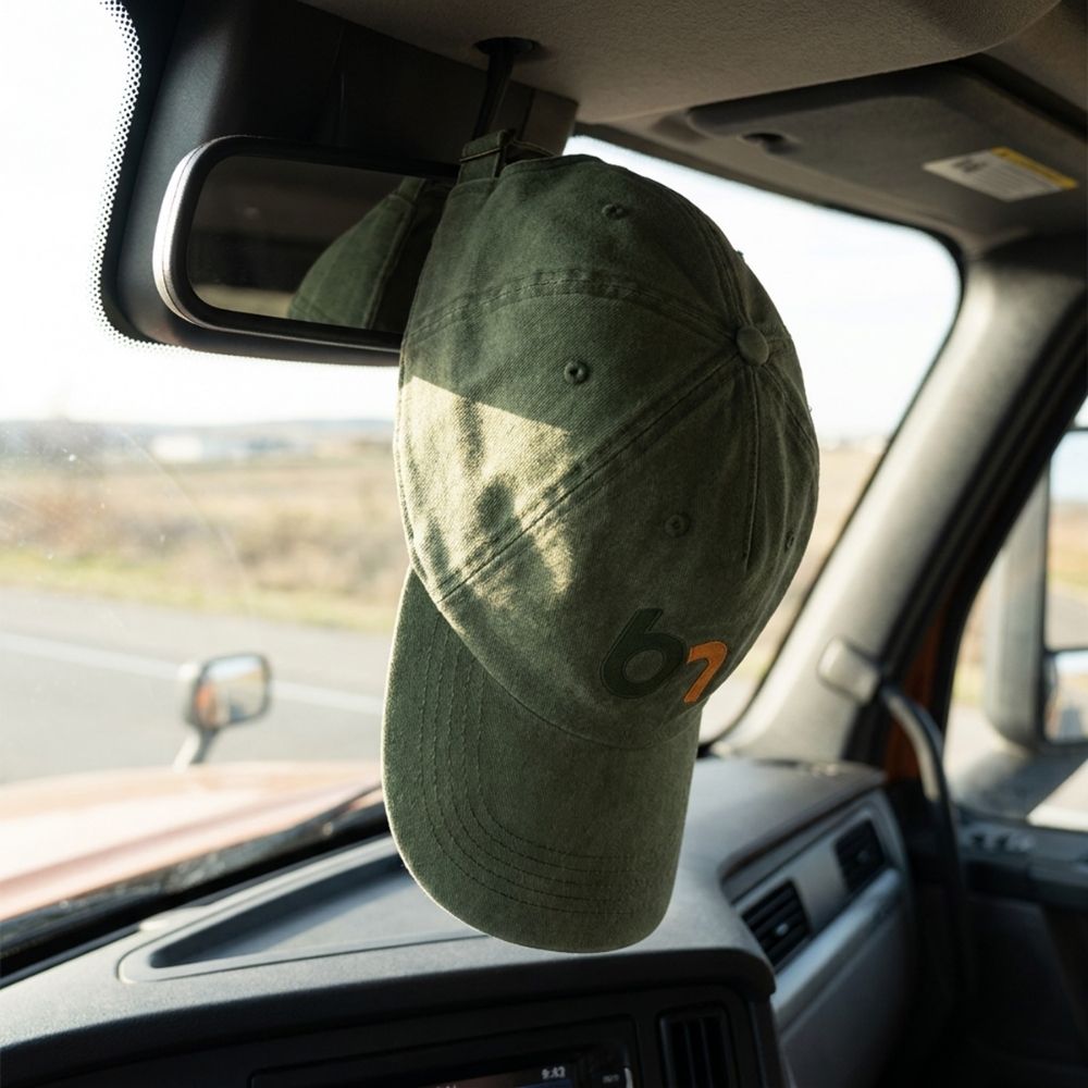 Promotional Caps and Headwear Australia Green embroidered cap hanging inside a vehicle showing subtle branded decoration