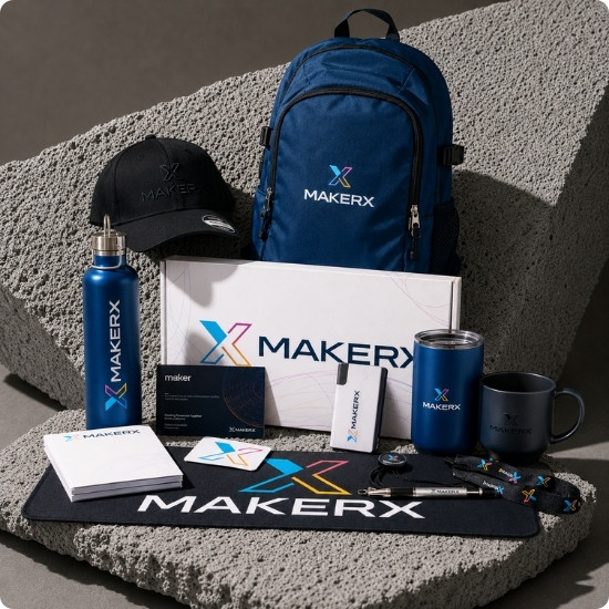 MakerX branded onboarding pack with backpack, water bottle and branded items on a desk